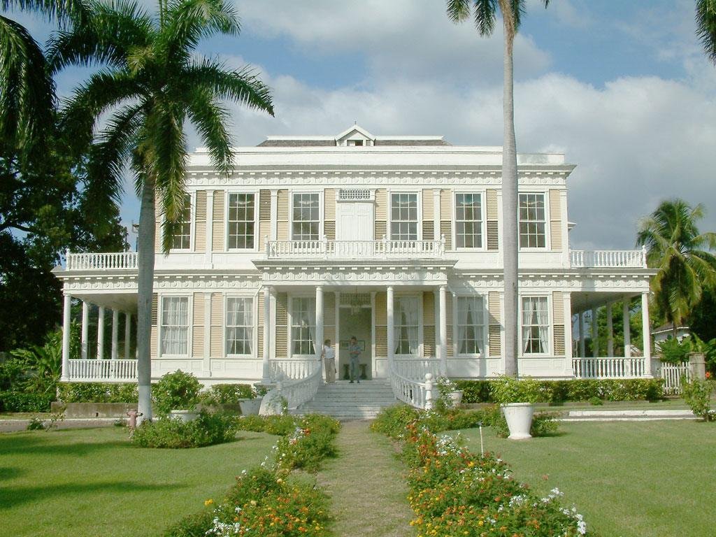 Devon House in Kingston, Jamaica: a white Georgian mansion with verandas, palm trees and a garden path